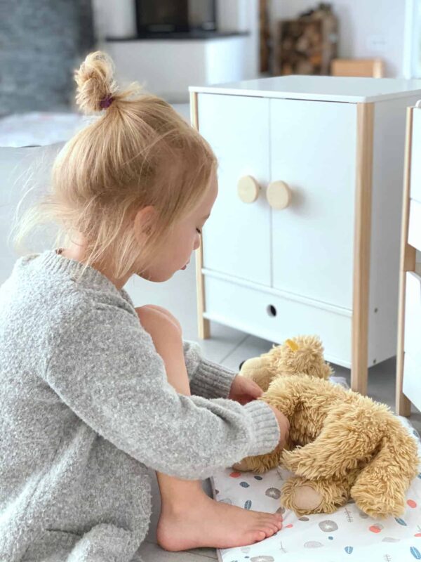 Der Small Foot Puppenschrank aus der Reihe „Little Button“ bietet mit einer Höhe von 48 cm viel Platz für Puppenkleider aller Art. Mit den leicht gängigen Flügeltüren kannst du den Puppenschrank bequem öffnen. Im Inneren findest du deine Kleiderstange und ein Fach, um Sachen zu verstauen. Ebenfalls enthalten sind spezielle Kleiderbügel, die über ein Gummiband verfügen. Damit eignen sie sich auch gut, um kleine Teile wie Schuhe oder Tücher zu verstauen. Um sicheres Spielen zu gewährleisten, sind alle Kanten abgerundet. Die weiße Farbgebung des Puppenschranks weiß sowohl Mädchen als auch Jungen zu gefallen. Der Schrank ist für Kinder ab 3 Jahren geeignet und passt perfekt zu allen anderen Produkten der „Little Button“-Reihe.