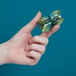 Metallischer Scharnier in Hand gehalten, isolierter Hintergrund.