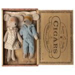 Weiß gestrickte Mäuserli mit Stoffkleidung, eines trägt ein Kleid mit Punkten, das andere einen Pyjama, im rustikalen Kartonbox.