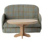 Gemütliches Sofa mit grünem Stoffbezug und orange Karo-Muster, kombiniert mit einem modernen hölzernen Beistelltisch, ideal für das stilvolle Wohnzimmer.